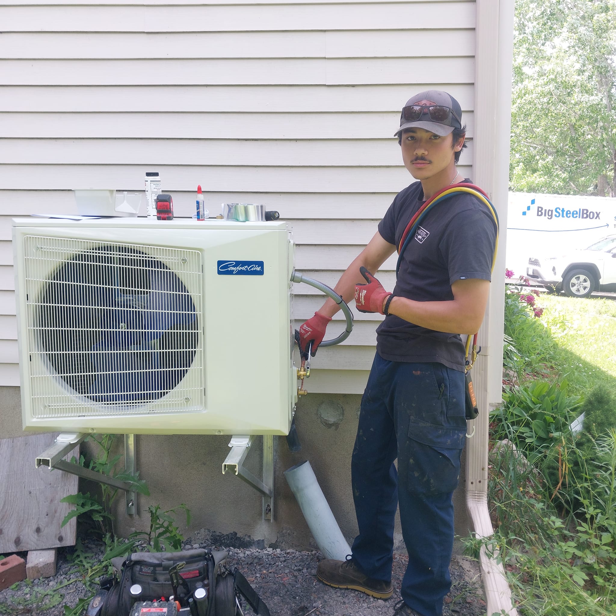 AirZone technician beside a newly installed side discharge heat pump.